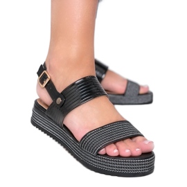 Sorte sandaler på en stor Senorita sål
