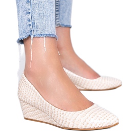 Beige pumps i et krokodillehudsmønster på Wildlife -kilehælen