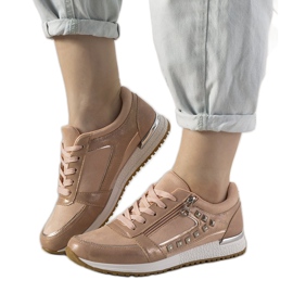 Lyserøde sports -sneakers dekoreret med Daphne -nitter