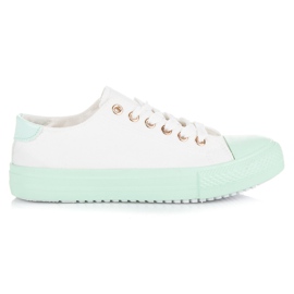 Hvide sneakers på den grønne platform