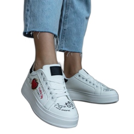 Hvide sneakers dekoreret med et plaster og inskriptioner på platformen