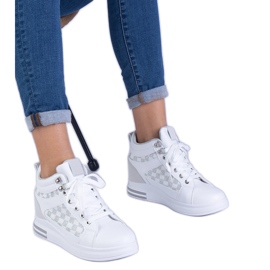 Kvinders hvide sneakers på en skjult kile