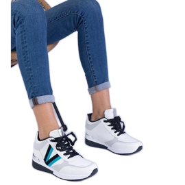 Hvide kvinders sneakers på en skjult kile