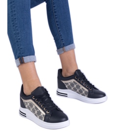 Sorte kvinders sneakers på en skjult kile