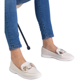 Beige loafers dekoreret med en bue og en gylden bamse