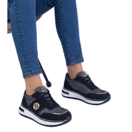 Sorte sneakers skinnende med en gylden dekoration