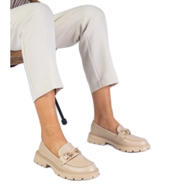 Beige kvindes loafers med en gylden dekoration