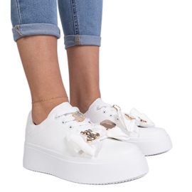 Kvinders hvide sneakers dekoreret med en bjørn
