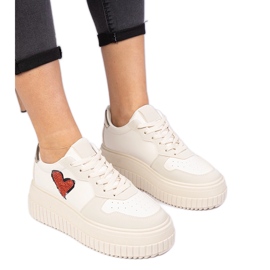 Beige kvindes sneakers med et brokadehjerte