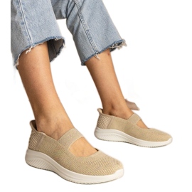 Beige kvindes sneakers på en presset sål