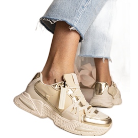Beige kvindes sneakers på en massiv sål
