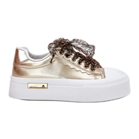 Kvinders sneakers på en massiv platform med dekorativt snøringsguld gylden
