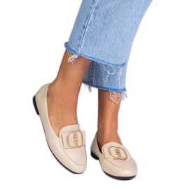 Beige kvindes loafers med en gylden dekoration