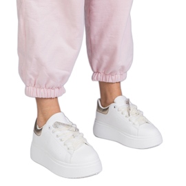 Hvide sneakers med en gylden indsats og en zirkonstift