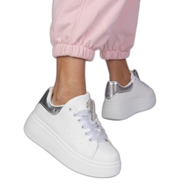 Hvide sneakers med en sølvindsats og en pin med zirkoner