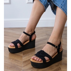 Sorte sandaler på platformen med en bundet rem