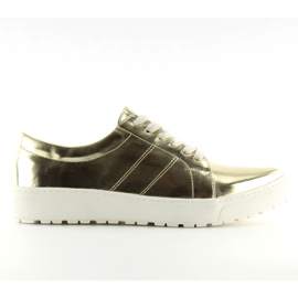 Kvinders loafers på en hvid sål. Guld gylden