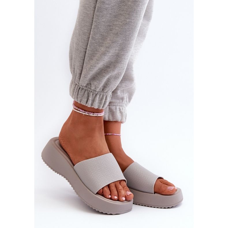 Kvinders flip-flops på en platform og kile grå vimarils 1