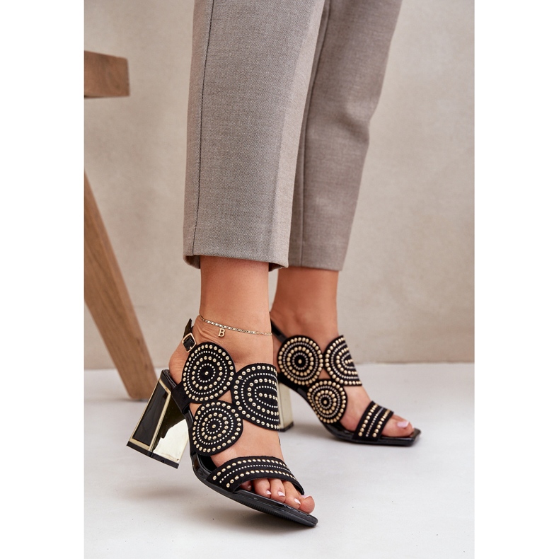 Dekorerede sandaler på den sorte stolpe 2